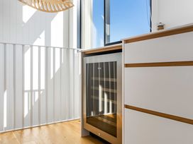 A kitchen with a wine cooler and cabinet at Waihi Beach Holiday Home