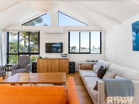 A living room with a sofa and television at Waihi Beach Holiday Home in Waihi Beach