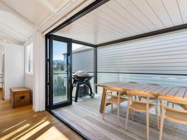 An outdoor patio with a dining table and grill at Waihi Beach Holiday Home Waihi Beach