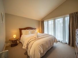 A bedroom with a bed and lamp at Te anau holiday home in Te Anau