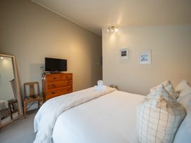 A bedroom with a bed, dresser, and TV at Te anau holiday home in Te Anau