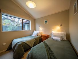 A bedroom with two beds and a window at Te Anau holiday home in Te Anau