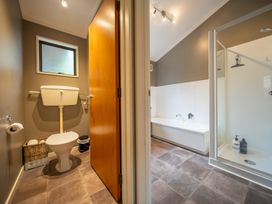 A bathroom with a toilet, sink, shower, and bathtub at Te anau holiday home in Te Anau