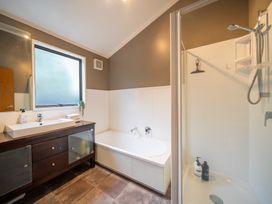 A bathroom with a bathtub, shower, and sink at Te anau holiday home in Te Anau