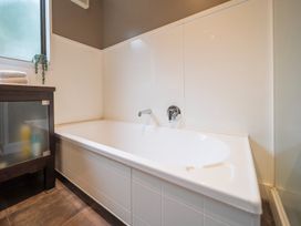 A bathroom with a bathtub and towels at Te anau holiday home in Te Anau