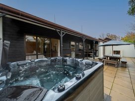 An outdoor area with a hot tub and seating at Te anau holiday home Te Anau