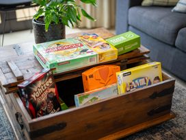 A coffee table with board games and a plant at Te anau holiday home in Te Anau