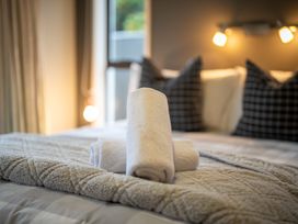 A bed with towels and pillows at Te anau holiday home in Te Anau