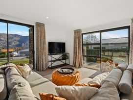 A living room with a sofa and a television at Mako Haven - Mountain Outlook in Wanaka