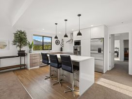 A kitchen with bar stools and modern appliances at Mako Haven - Mountain Outlook in Wanaka
