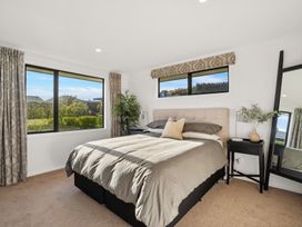 A bedroom with a bed and windows at Mako Haven - Mountain Outlook in Wanaka