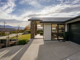 An outdoor view of a house with a garage and pathway at Mako Haven - Mountain Outlook Wanaka