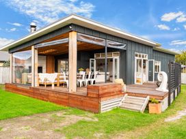 A house with a deck and dining area at Sweet Seabreeze - Mangawhai Heads Holiday Home Mangawhai