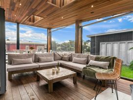 A seating area with a sofa and coffee table at Sweet Seabreeze - Mangawhai Heads Holiday Home, Mangawhai
