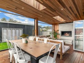 An outdoor dining area with a table and chairs at Sweet Seabreeze - Mangawhai Heads Holiday Home, Mangawhai