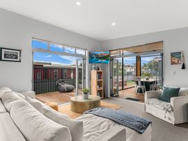 A living room with a coffee table and television at Sweet Seabreeze - Mangawhai Heads Holiday Home, Mangawhai