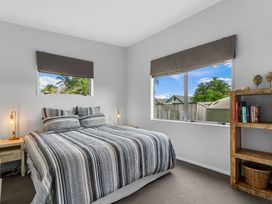 A bedroom with a bed and bookshelf at Sweet Seabreeze - Mangawhai Heads Holiday Home, Mangawhai