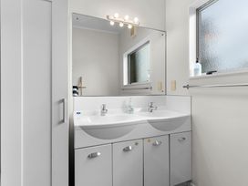 A bathroom with a double sink and mirror at Sweet Seabreeze - Mangawhai Heads Holiday Home, Mangawhai