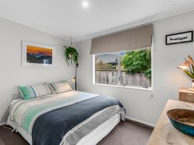 A bedroom with a bed and window at Sweet Seabreeze - Mangawhai Heads Holiday Home, Mangawhai