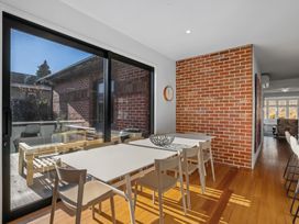 A dining room with a table and chairs near large windows at Cromwell Holiday Home in Cromwell