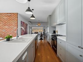 A kitchen with cabinets, stove, and table at Cromwell Holiday Home in Cromwell