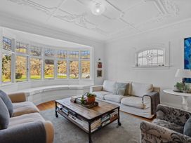 A living room with a coffee table and large windows at Cromwell Holiday Home in Cromwell