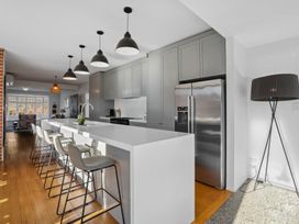 A kitchen with a refrigerator and bar stools at Cromwell Holiday Home in Cromwell