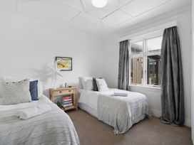 A bedroom with two beds and a bedside table at Cromwell Holiday Home in Cromwell