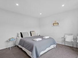 A bedroom with a bed and chairs at Cromwell Holiday Home in Cromwell