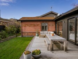 An outdoor area with a wooden table and seating at Cromwell Holiday Home in Cromwell
