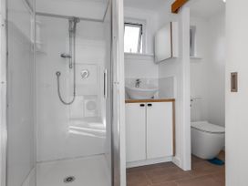 A bathroom featuring a shower, sink, and toilet at Ahipara in Kaitaia