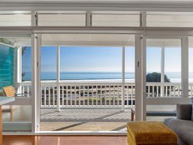 A living room with a view of the ocean and beach at Ahipara in Kaitaia