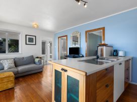 A living room with a sofa and television at Ahipara, Kaitaia