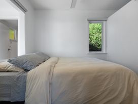 A bedroom with a bed and a window at Ahipara in Kaitaia