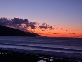A beach scene during sunset at Te Hu - Ahipara Beachfront Bach Ahipara