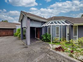 An entrance of a house with a garage and plants at Solar House - Kerikeri Holiday House in Kerikeri