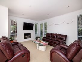 A living room with a fireplace and a TV at Solar House - Kerikeri Holiday House in Kerikeri