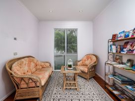 A snug with a sofa and a table at Solar House - Kerikeri Holiday House in Kerikeri