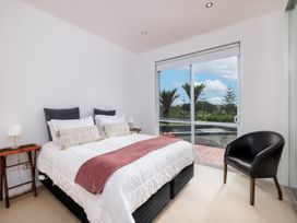 A bedroom with a bed and bedside table at Solar House - Kerikeri Holiday House in Kerikeri