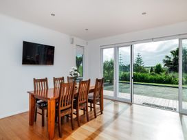 A dining room with a table and chairs at Solar House - Kerikeri Holiday House in Kerikeri