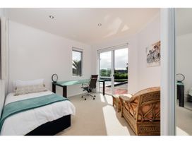 A bedroom with a bed and desk at Solar House - Kerikeri Holiday House in Kerikeri
