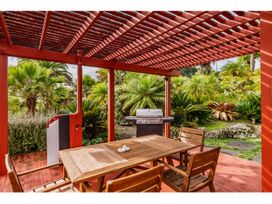 An outdoor dining area with a table and grill at Solar House - Kerikeri Holiday House in Kerikeri