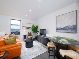 A living room with a sofa and dining area at Ocean Whisper Retreat - Kaikoura Holiday Home