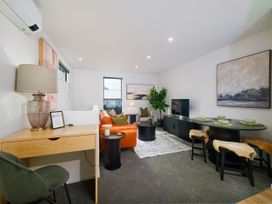 A living room with a sofa and dining table at Ocean Whisper Retreat - Kaikoura Holiday Home