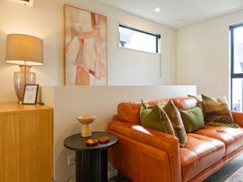 A living room with a sofa and lamp at Ocean Whisper Retreat - Kaikoura Holiday Home