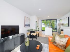 A living room with a television and dining area at Ocean Whisper Retreat - Kaikoura Holiday Home in Kaikoura