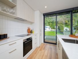 A kitchen with cabinets and a view at Ocean Whisper Retreat - Kaikoura Holiday Home in Kaikoura