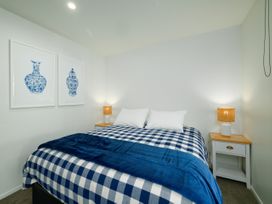 A bedroom with a bed and nightstand at Ocean Whisper Retreat - Kaikoura Holiday Home