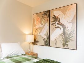 A bedroom with a bed and wall art at Ocean Whisper Retreat - Kaikoura