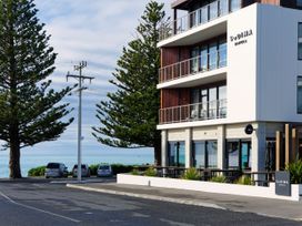 A hotel with balconies and trees at Sudima in Kaikoura